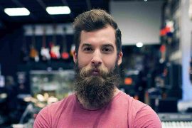 A bearded man stands inside a shop, representing Arthur Springs and his connection to music.