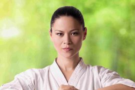 A female karate instructor demonstrates a powerful stance, showcasing the discipline of martial arts.