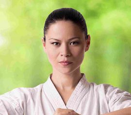 A female karate instructor demonstrates a powerful stance, showcasing the discipline of martial arts.