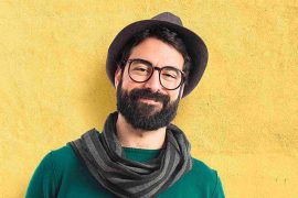A bearded man wearing a hat and scarf, representing the character Peter Parker.