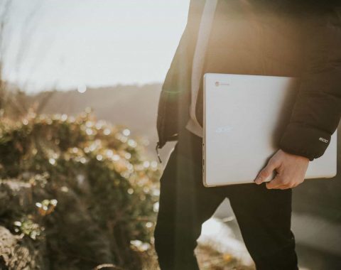 A student uses a Chromebook for online english language learning outdoors.